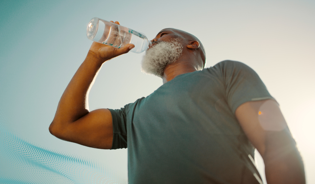 A man drinking from a water bottle on a sunny day