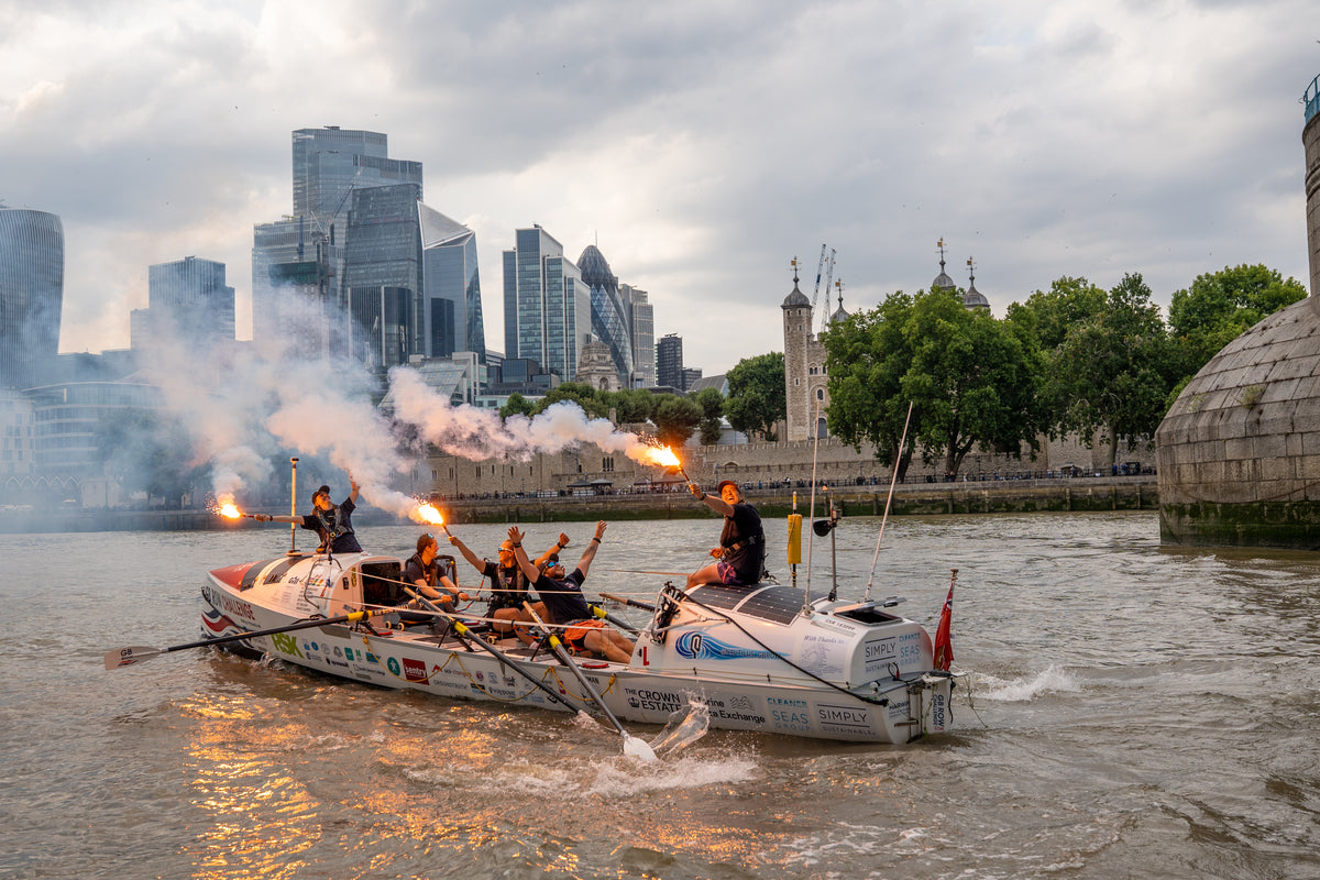 Team Nautilus rowing past the Tower of London with flares firing on approach to the finish